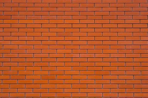 Wall of red facing bricks with cement Stock Photos