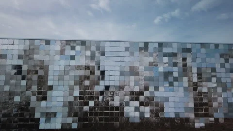 A wall of reflective rows of plexiglass panels moving in tandem with a fast Video stock 303499144