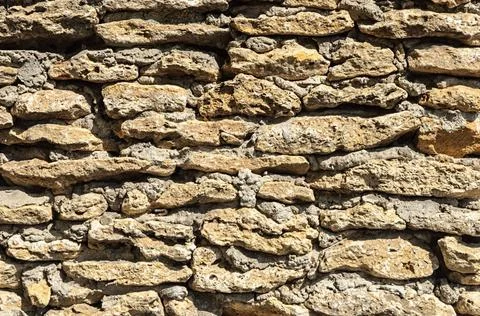 Wall of rough stones shell Texture of brown stone coquina wall with cement... Stock Photos