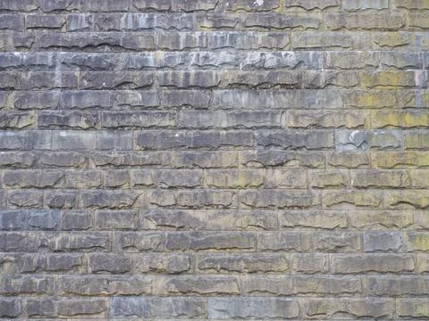 Wall with rough textured masonry covered with stains and darkened. Not seamless 스톡 사진