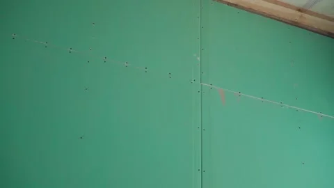 The wall is sheathed with green moisture-resistant drywall, smooth camera Stock Footage 237758117