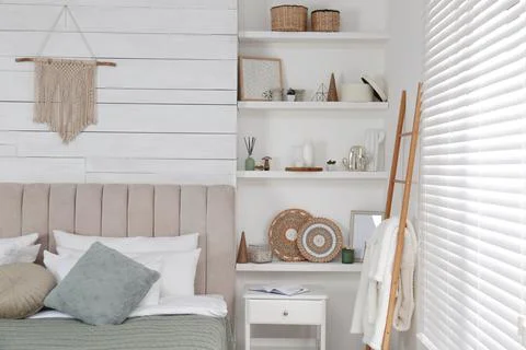 Wall shelves with beautiful decor elements in stylish bedroom interior Stock Photos