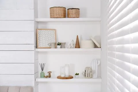 Wall shelves with beautiful decor elements indoors. Interior design Stock Photos