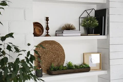 Wall shelves with beautiful decor elements indoors. Interior design Stock Photos
