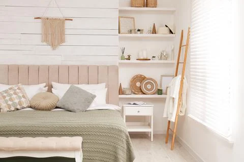 Wall shelves with beautiful decor elements in stylish bedroom interior Stock Photos