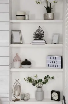 Wall shelves with beautiful decor elements indoors. Interior design Stock Photos