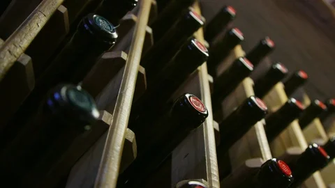 Wall with shelves of light wood with inserted bottles of white and red wine. Stock Footage 111308570