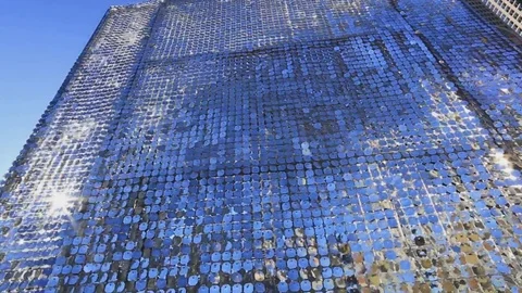 Wall of Shimmering Paillettes reflecting the clouds, sky, and buildings Video stock 83260703