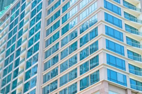 Wall of skyscraper with blue windows on corner Stock Photos