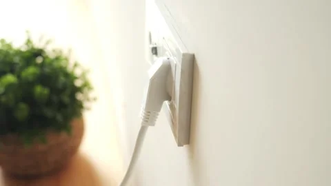Wall socket with plugged in cable in bright room Stock Footage 310081702