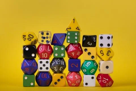 Wall of stacked piled game dice on a bright yellow background Stock Photos