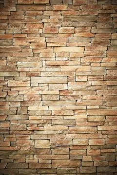 Wall of stone beige surface bricks as a background. Stock Photos