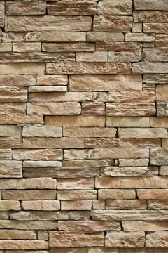 Wall of stone beige surface bricks as a background. Stock Photos