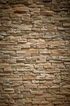 Wall of stone beige surface bricks as a background. Stock Photos