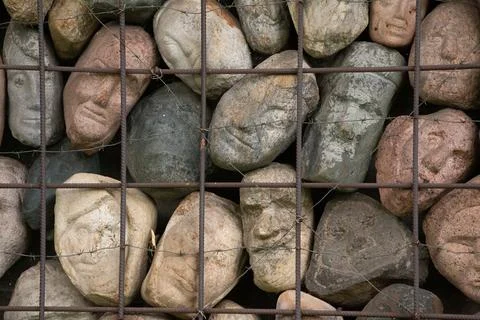 A wall of stones in the shape of human faces Foto stock