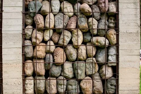 A wall of stones in the shape of human faces Foto stock