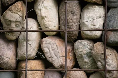 A wall of stones in the shape of human faces Foto stock