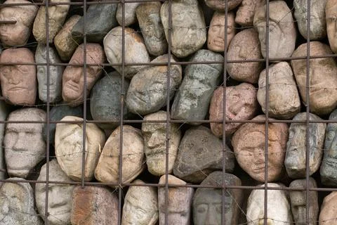 A wall of stones in the shape of human faces Foto stock