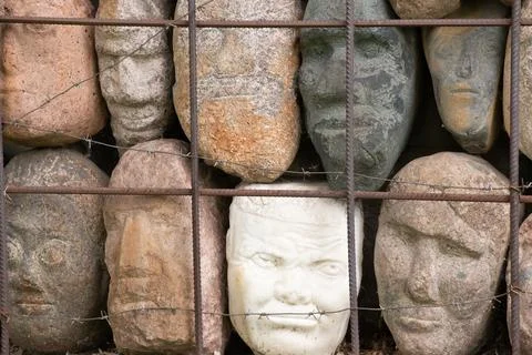 A wall of stones in the shape of human faces Foto stock