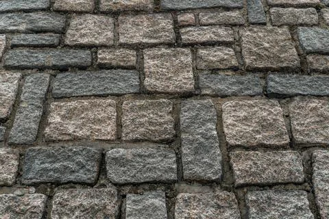 Wall in the street from grey bricks. Stock Photos