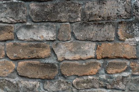 Wall in the street from grey bricks. Stock Photos