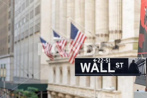 Wall street sign and New York Stock Exchange background. Stock Photos