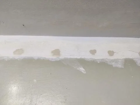 Wall surface with horizontal repair strip and patch marks Stock Photos