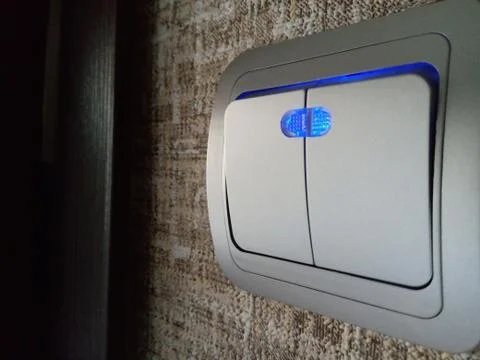 On the wall switch with LED backlight. Close-up. 写真素材