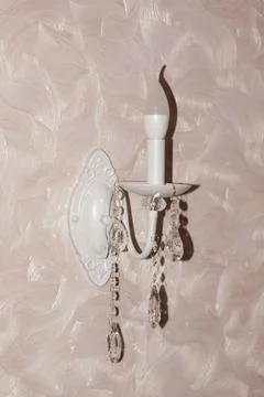On the wall there is a decorative wall lamp in the shape of a candlestick Stock Photos