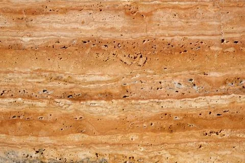 Wall of travertine with stone layers of different colors. Close up architecture Stock Photos