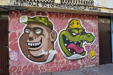 A wall with two faces and a crocodile on it in Guadalajara Downtown Stock Photos