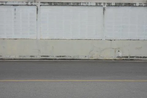 A wall with a white brick border and a grey cement wall Stock Photos