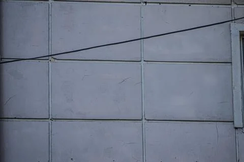 A wall with a white brick pattern and a wire running across it. Stock Photos