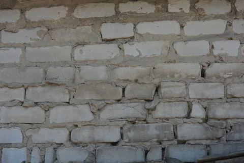 Wall of white smooth brick with gray cement masonry, construction error. Stockfoto's