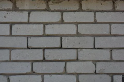 Wall of white smooth brick with gray cement masonry, construction error. Stockfoto's