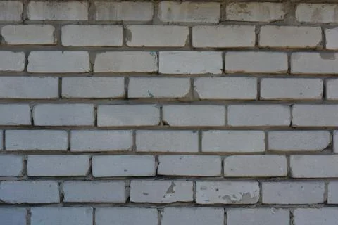 Wall of white smooth brick with gray cement masonry, construction error. Stock Photos