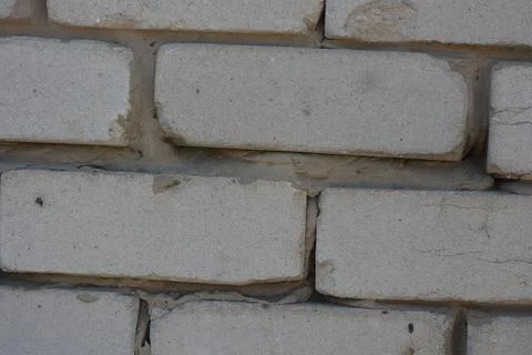 Wall of white smooth brick with gray cement masonry, construction error. 写真素材