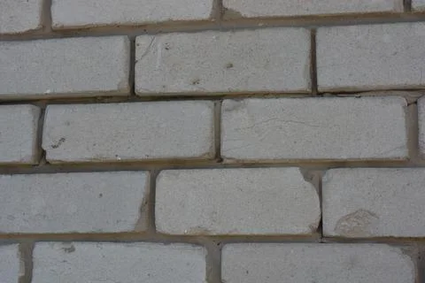 Wall of white smooth brick with gray cement masonry, construction error. 写真素材