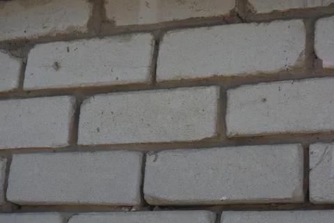 Wall of white smooth brick with gray cement masonry, construction error. 写真素材