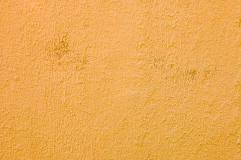 A wall with worn orange plaster. Stock Photos