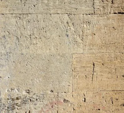 Wall of yellow rectangular stones with cement Stock Photos