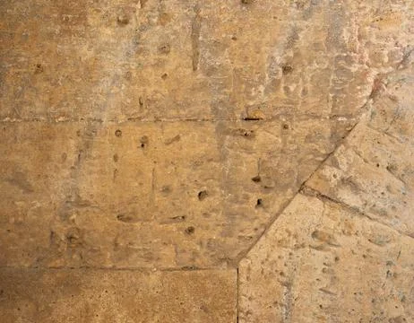 Wall of yellow rectangular stones with cement, fragment of ancient architectu Foto stock