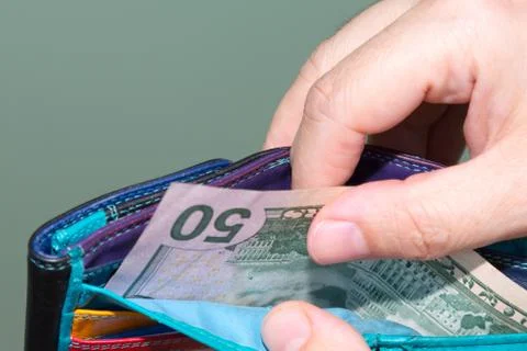 Wallet with dollars close-up. a middle-aged lady keeps pulling money out Foto stock