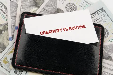 A wallet sits on a table with bills around it. There is a business card in th Foto stock