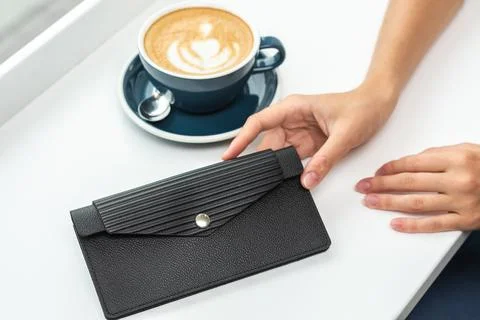 Wallet on a white table with a cup of coffee Stock Photos