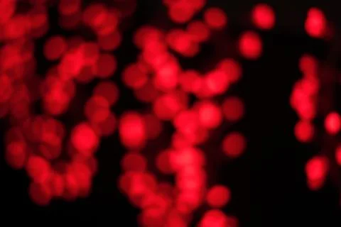 Wallpaper patterned with round shaped red lights bokeh on black background Stock Photos