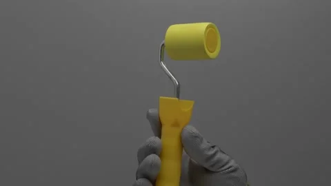 Wallpaper pressure roller in hand on a gray background. Видео 265598102