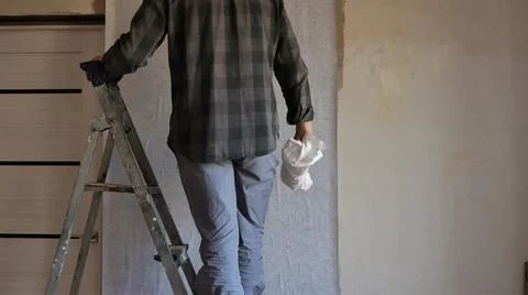 Wallpapering in an apartment with a stepladder Stock Photos