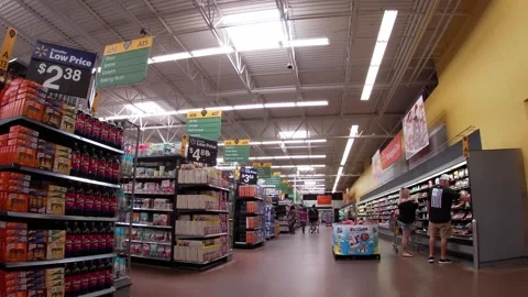 Walmart super center interior lady with cart wearing face masks passes by Stock Footage 157615129