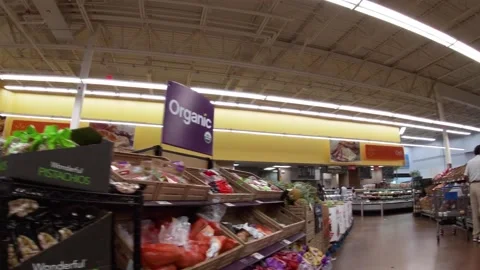 Walmart super center interior Pan in to a person selecting produce items . Stock Footage 157615035
